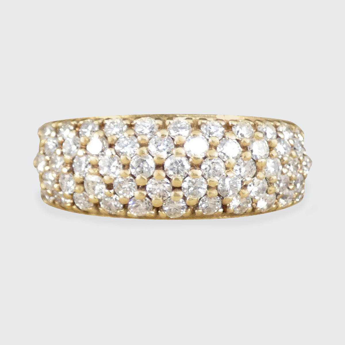 A diamond set domed ring in yellow gold