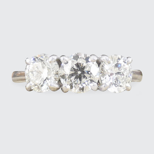 Three-stone diamond ring on a light gray background