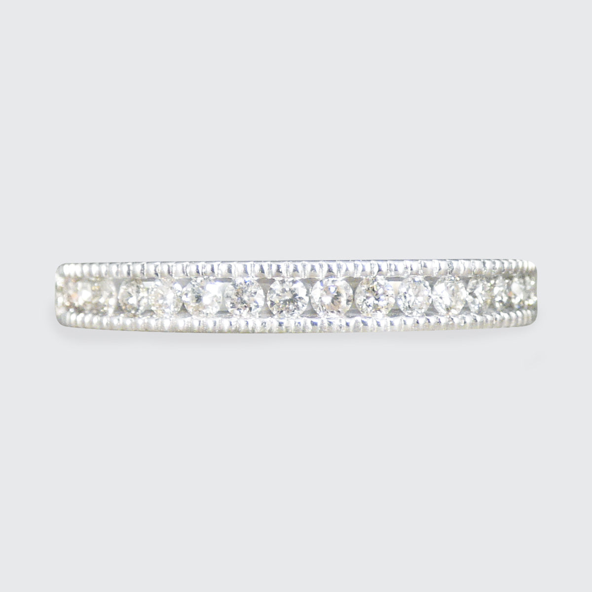 Diamond eternity ring on a light gray background