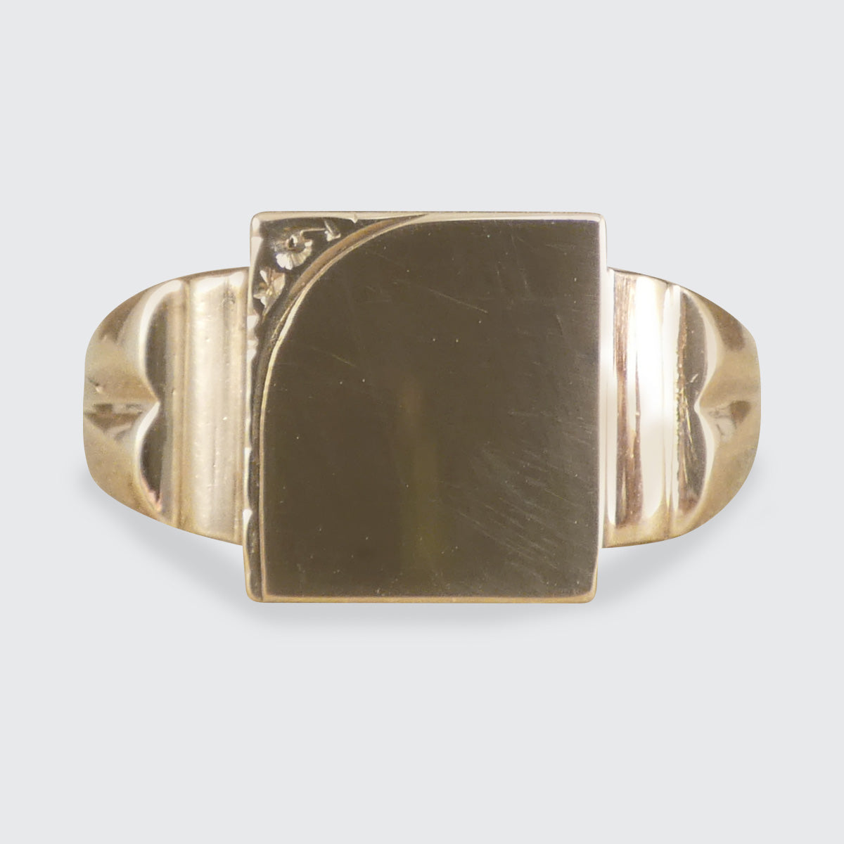 Gold Signet ring with a square stone on a light gray background