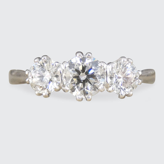 Three-stone diamond ring on a light gray background