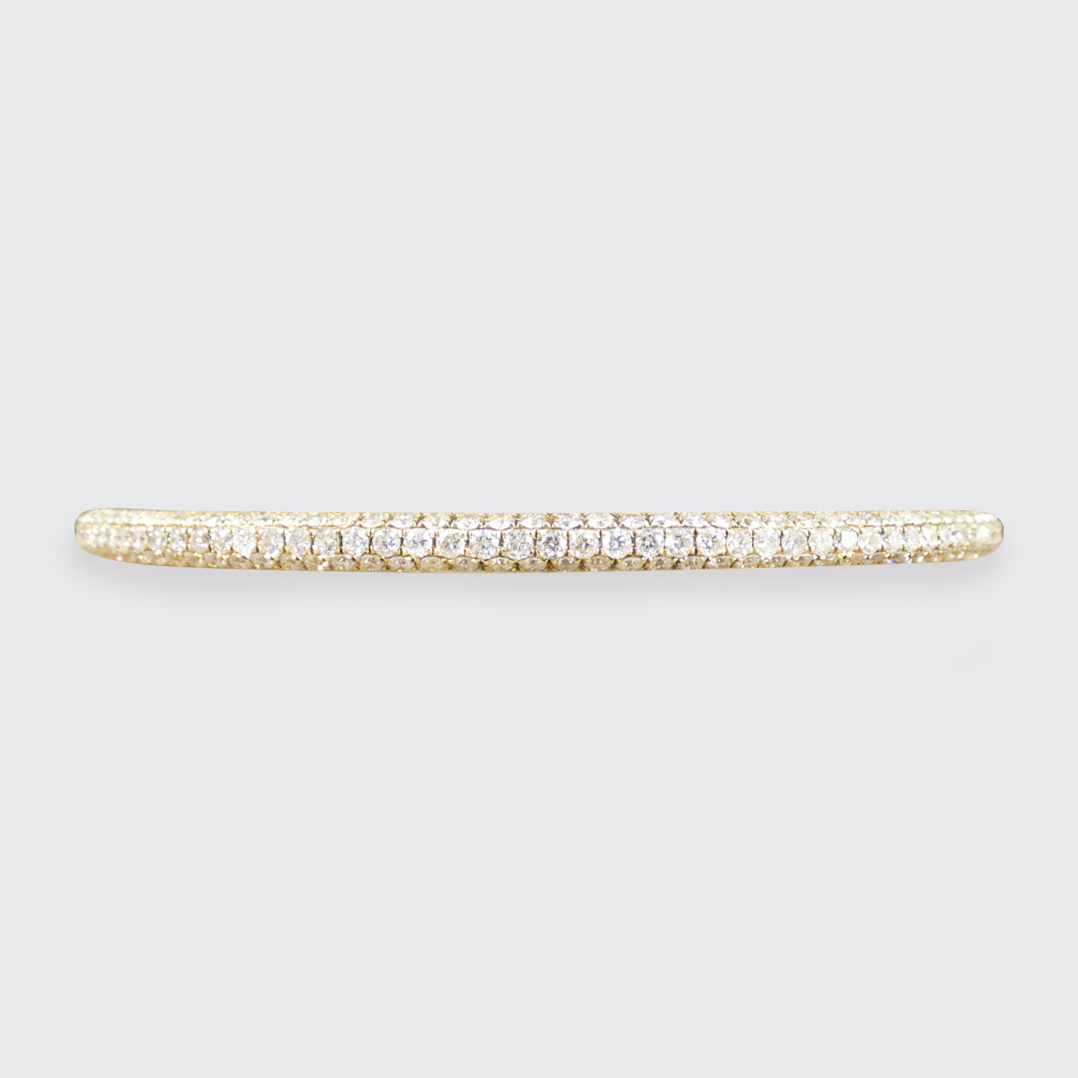 Gold bracelet with diamonds on a light gray background