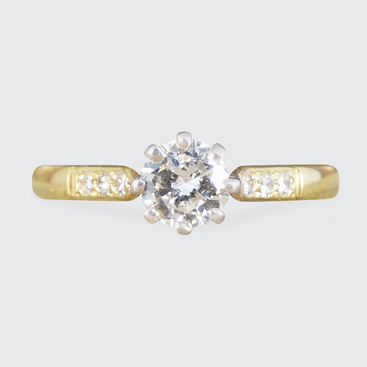A diamond solitaire with diamond set shoulder in yellow gold