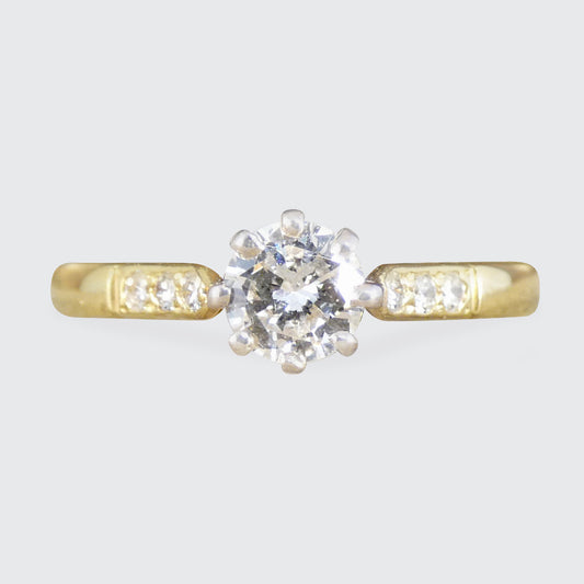 A diamond solitaire with diamond set shoulder in yellow gold