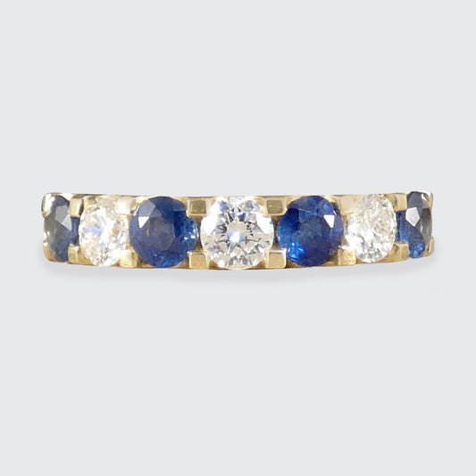 A Sapphire and Diamond half eternity ring in yellow gold.