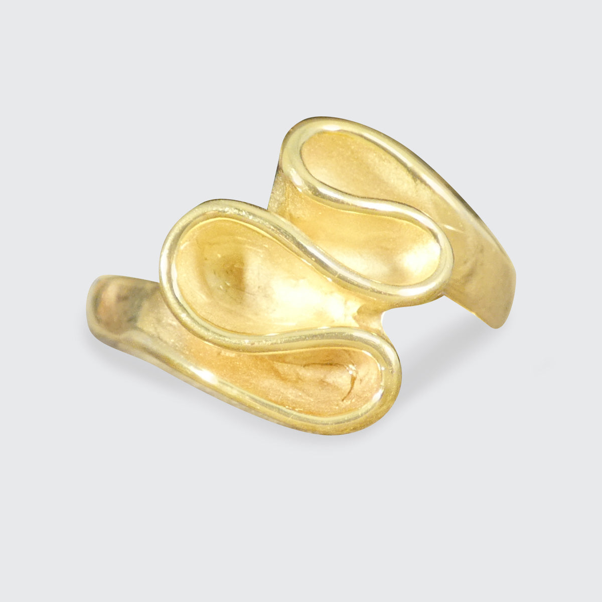 Gold ring with a unique design on a light gray background