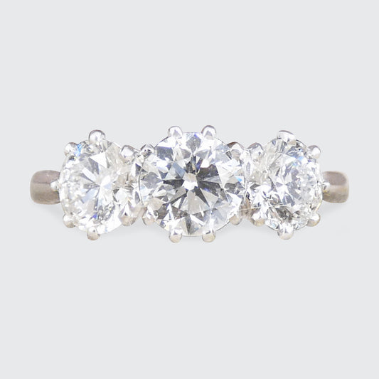 Three-stone diamond ring on a light gray background