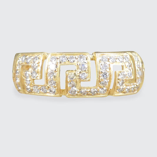 Gold ring with diamond accents on a light gray background