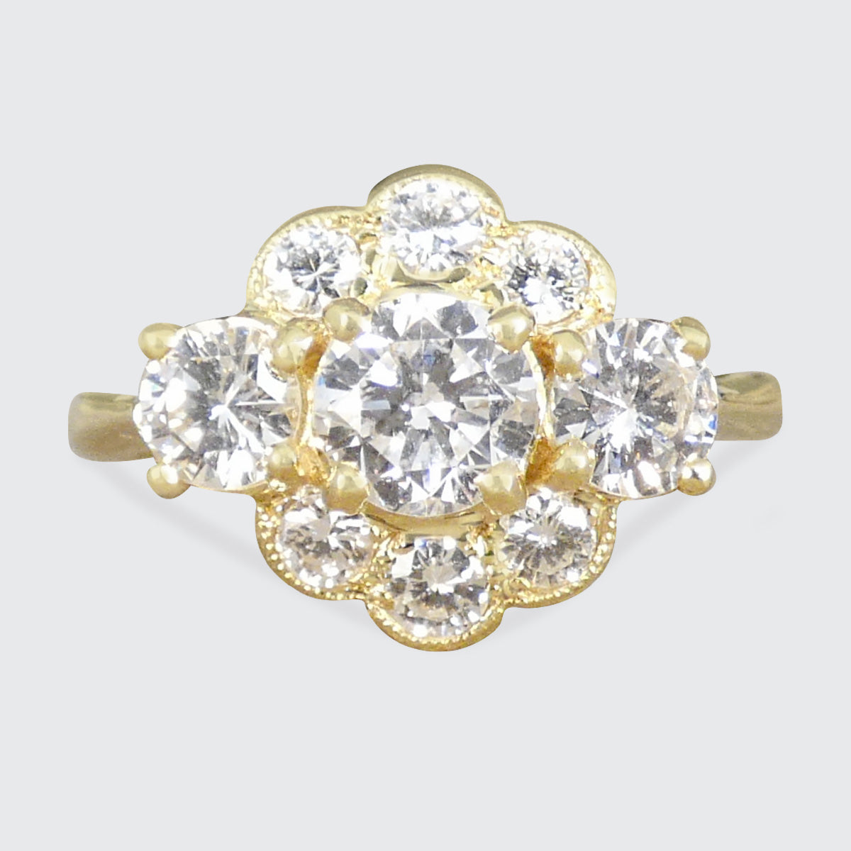 Gold ring with diamond gemstones on a light gray background