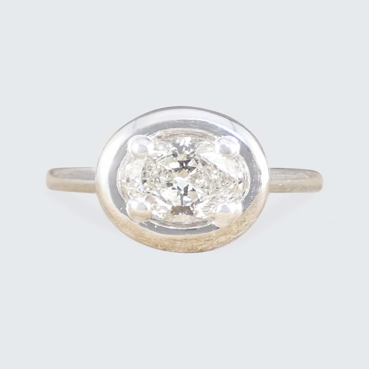 Oval Cut Diamond Ring in a chunky bezel setting set east west.