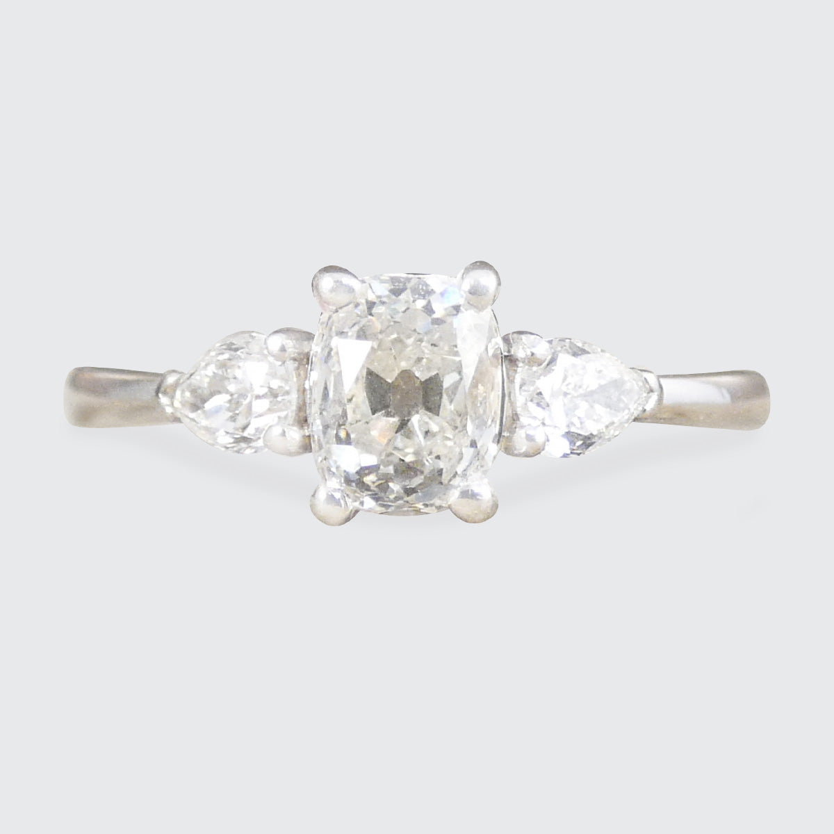 Diamond ring with three stones on a light gray background