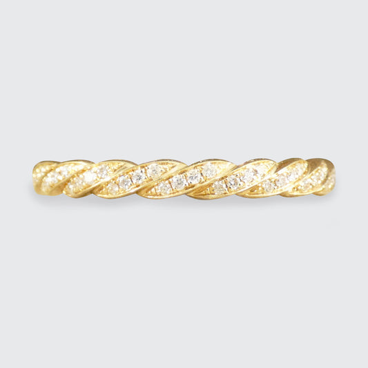 Gold ring with diamond accents on a light gray background