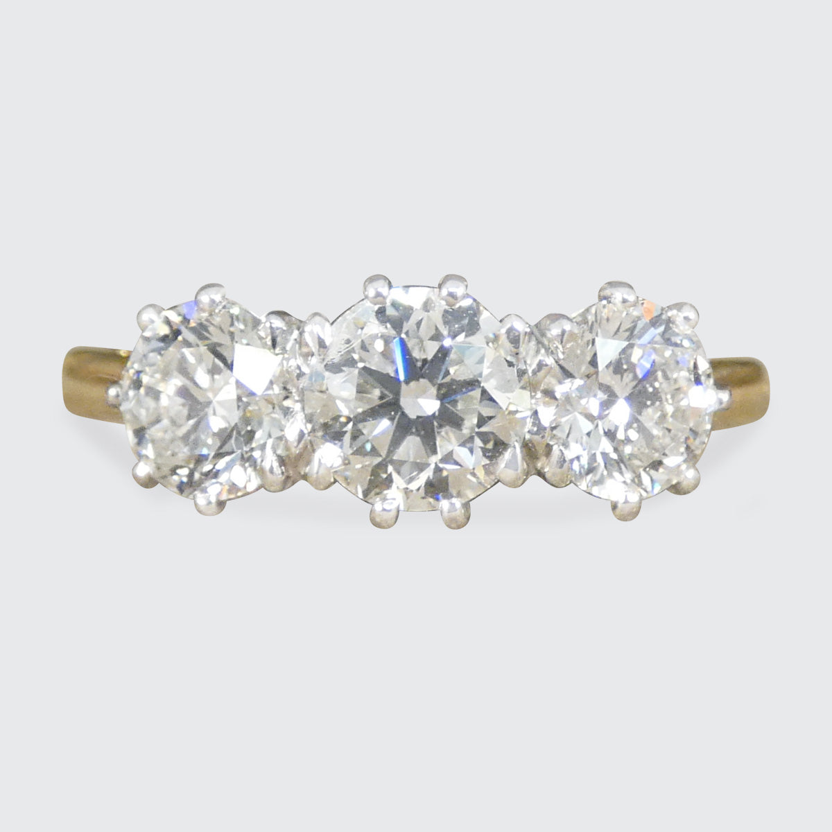 A classic three stone diamond ring in platinum and 18ct yellow gold.