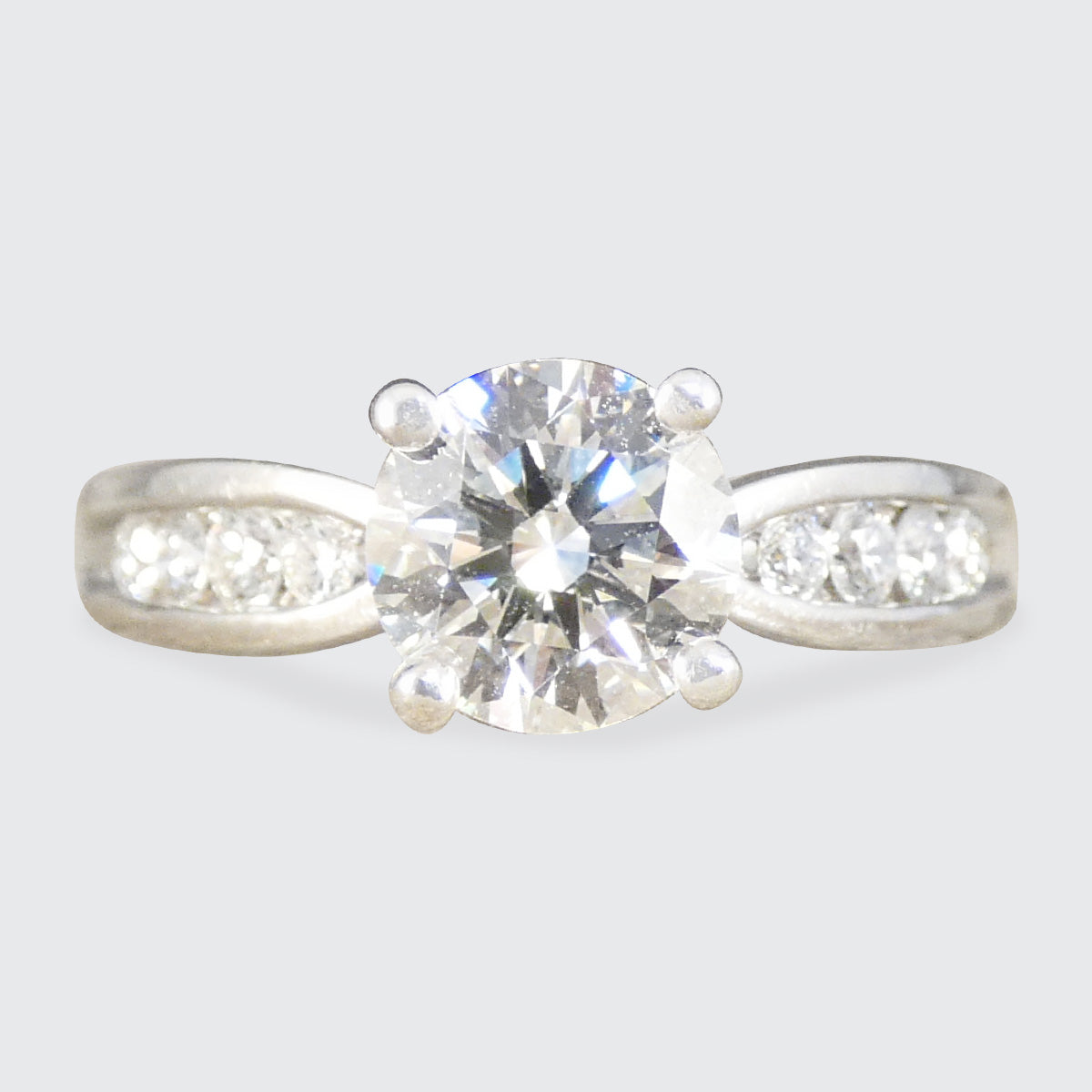 Diamond ring with a clear gemstone on a light gray background