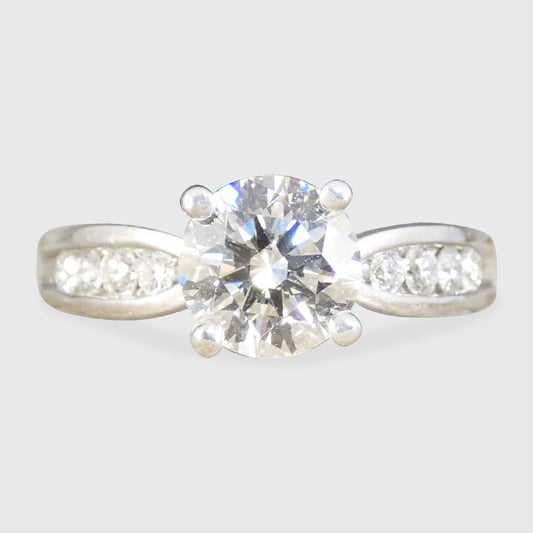 Diamond ring with a clear gemstone on a light gray background
