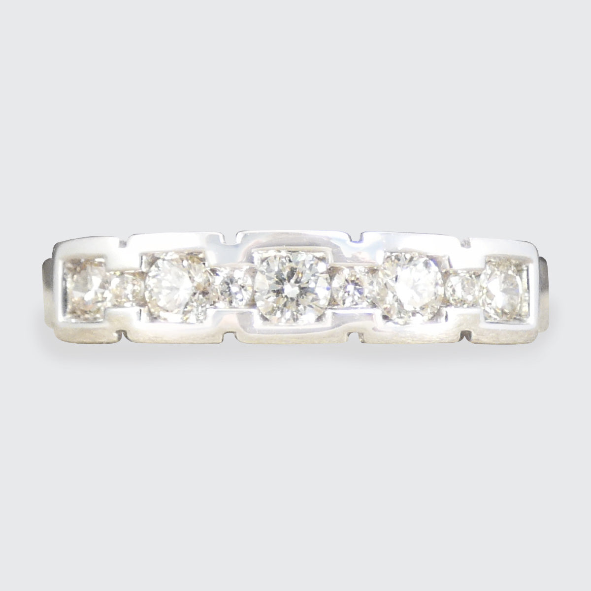 Diamond ring with five stones on a light gray background