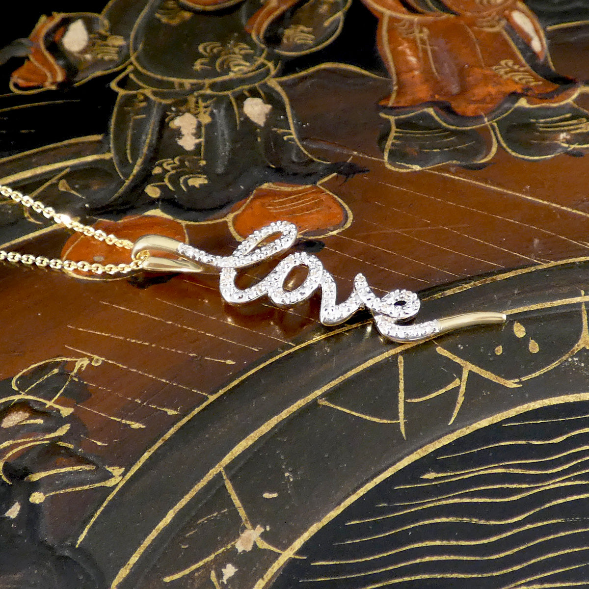 Necklace with 'Love' pendant on an ornate background