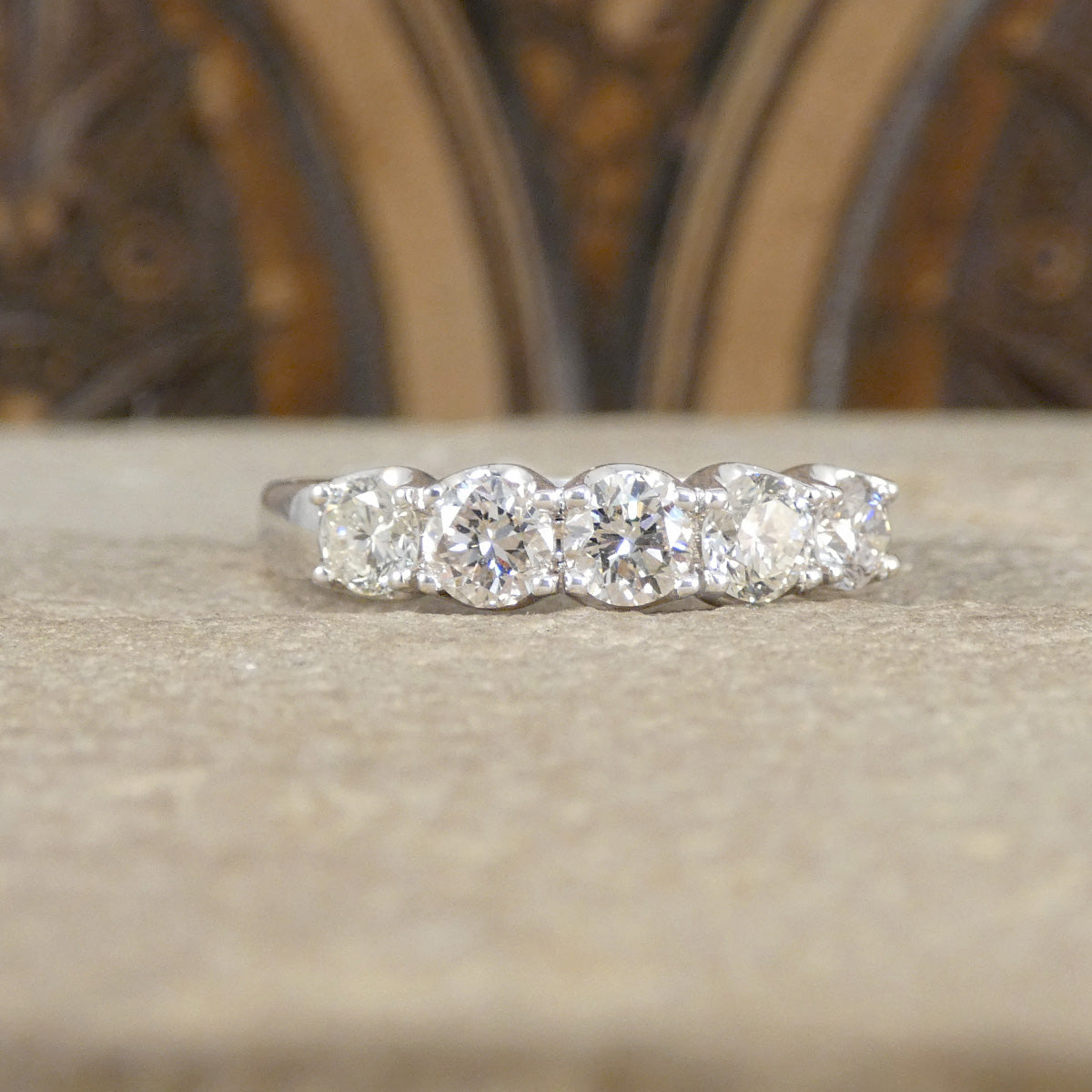 Diamond ring on a textured surface with a blurred decorative background