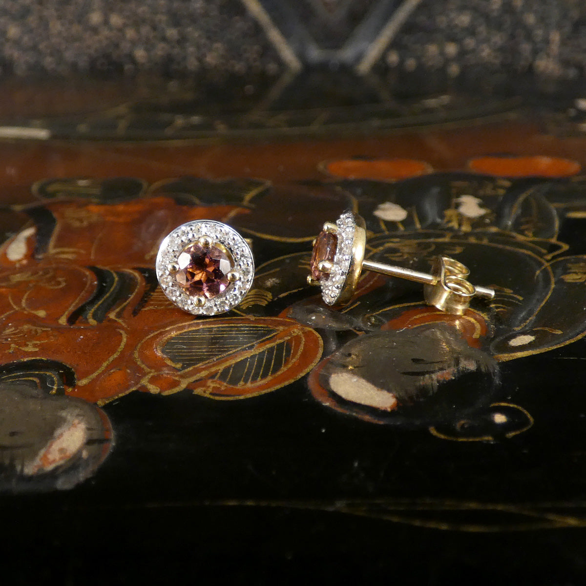 Pair of earrings with gemstones on a decorative surface