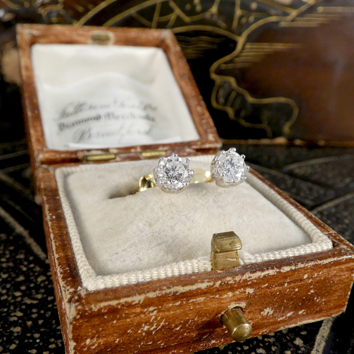 Diamond ring in a wooden box with a decorative background