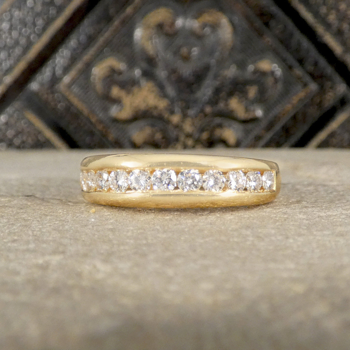 Gold ring with diamonds on a textured surface