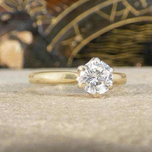 Gold ring with a diamond on a stone surface