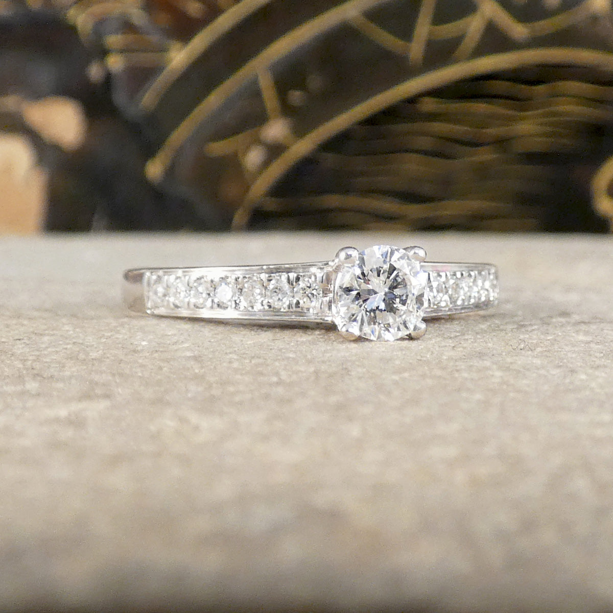 Diamond ring on a textured surface with blurred decorative background