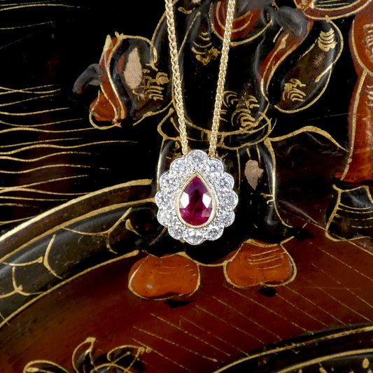 Gold necklace with a red ruby gemstone pendant on an ornate black and gold background