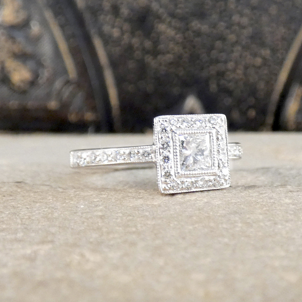 Silver ring with a diamond on a textured surface
