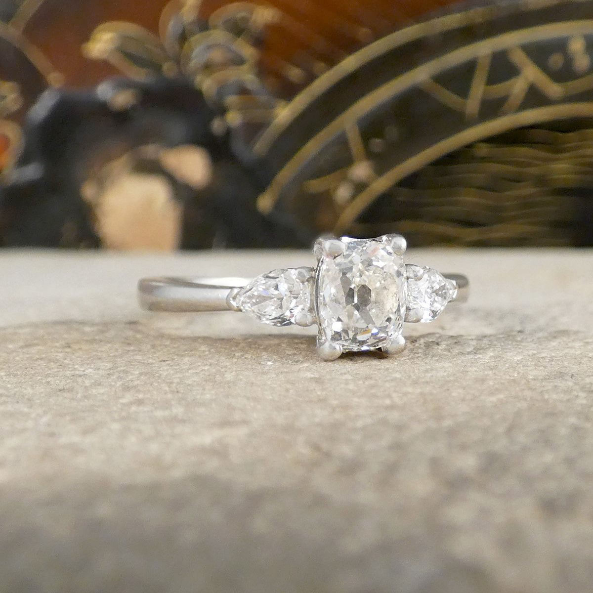 Diamond ring on a textured surface with a blurred decorative background