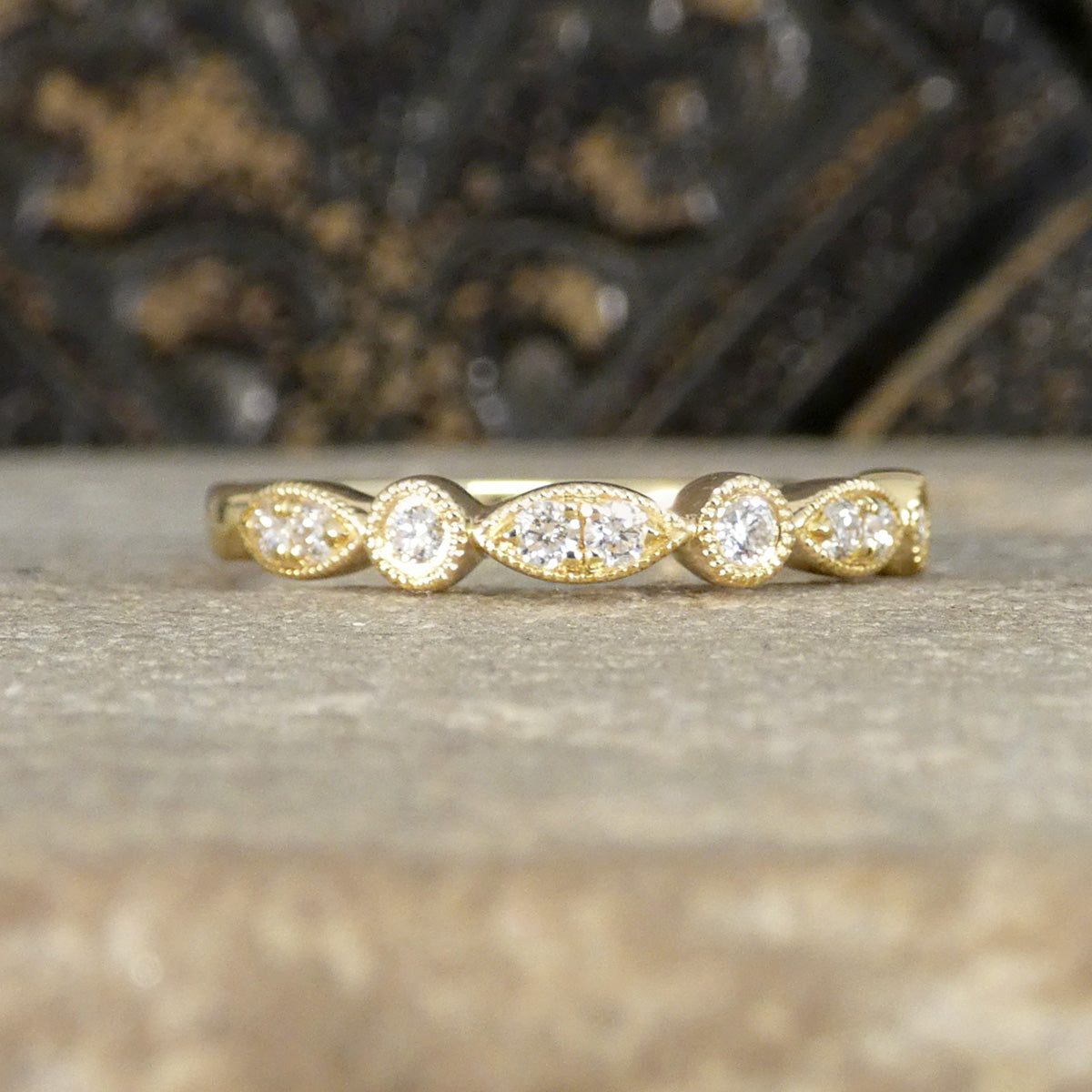 Gold ring with diamonds on a textured surface