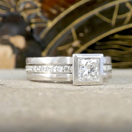 Platinum fusion ring with a diamond on a stone surface