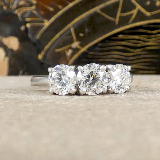 Three-stone diamond ring on a neutral surface with a blurred background