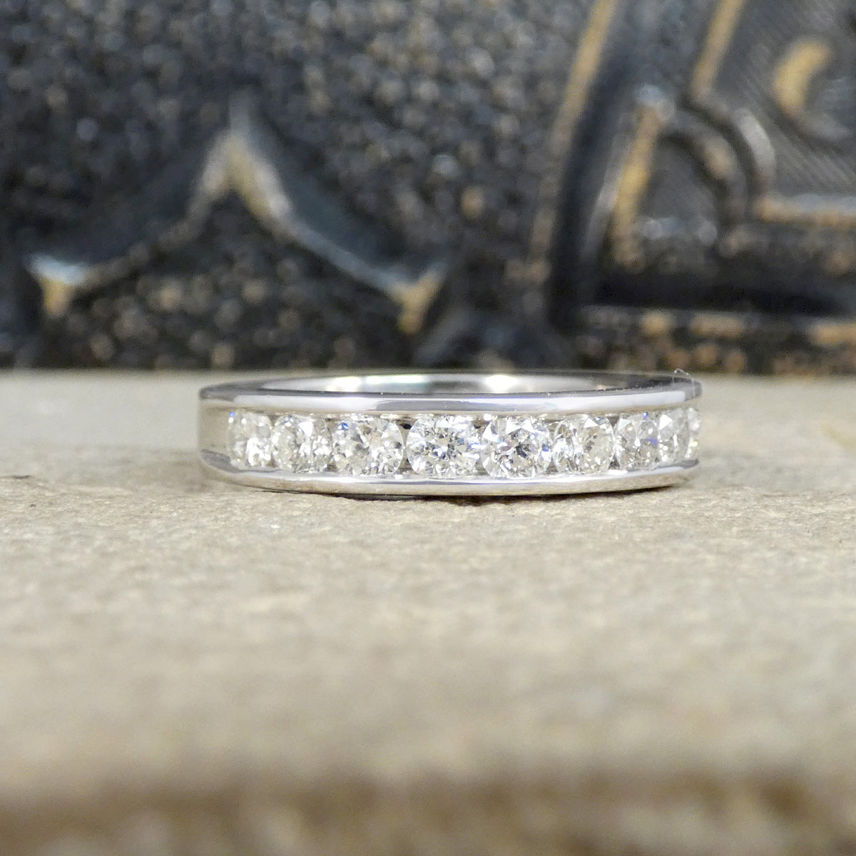 White Gold ring with channel set diamonds on a textured surface