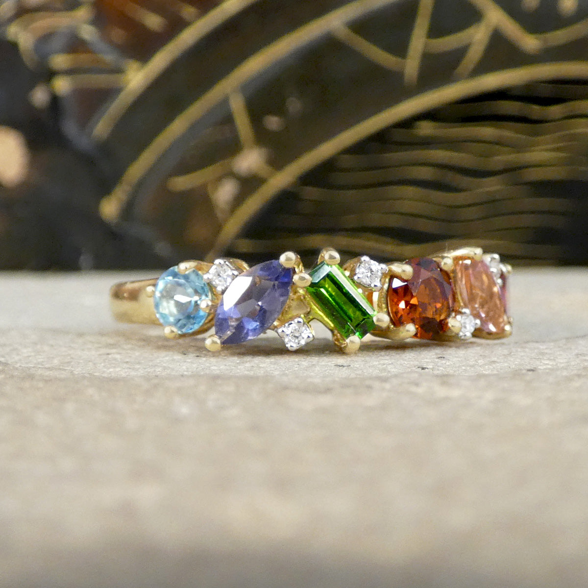 Ring with multicolored gemstones on a wooden surface
