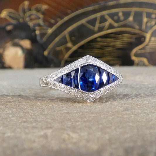 A gorgeous Art Deco style Sapphire and Diamond cluster ring in Platinum. The perfect ring for a unique gift.