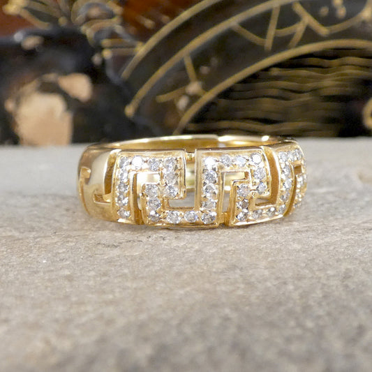 Gold ring with diamond accents on a textured surface