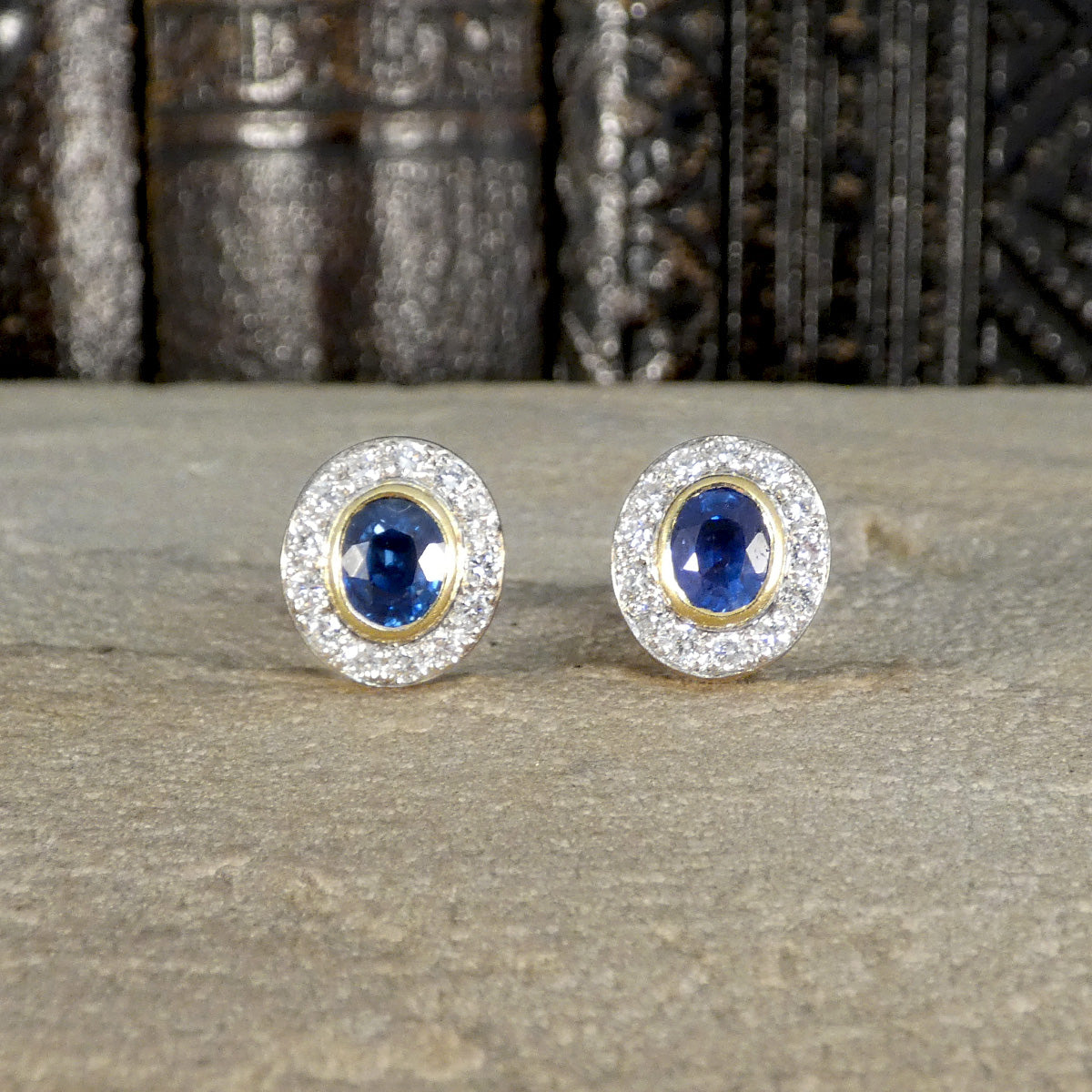 A beautifully bright pair of sapphire and diamond stud earrings in 18ct gold with a bezel setting.