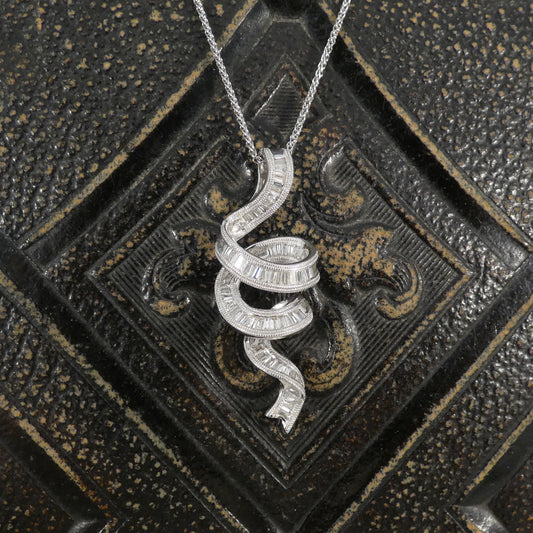 White Gold ribbon shaped pendant necklace on a textured black background