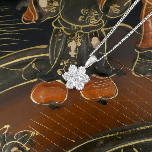 white gold necklace with a diamond pendant on an ornate wooden surface