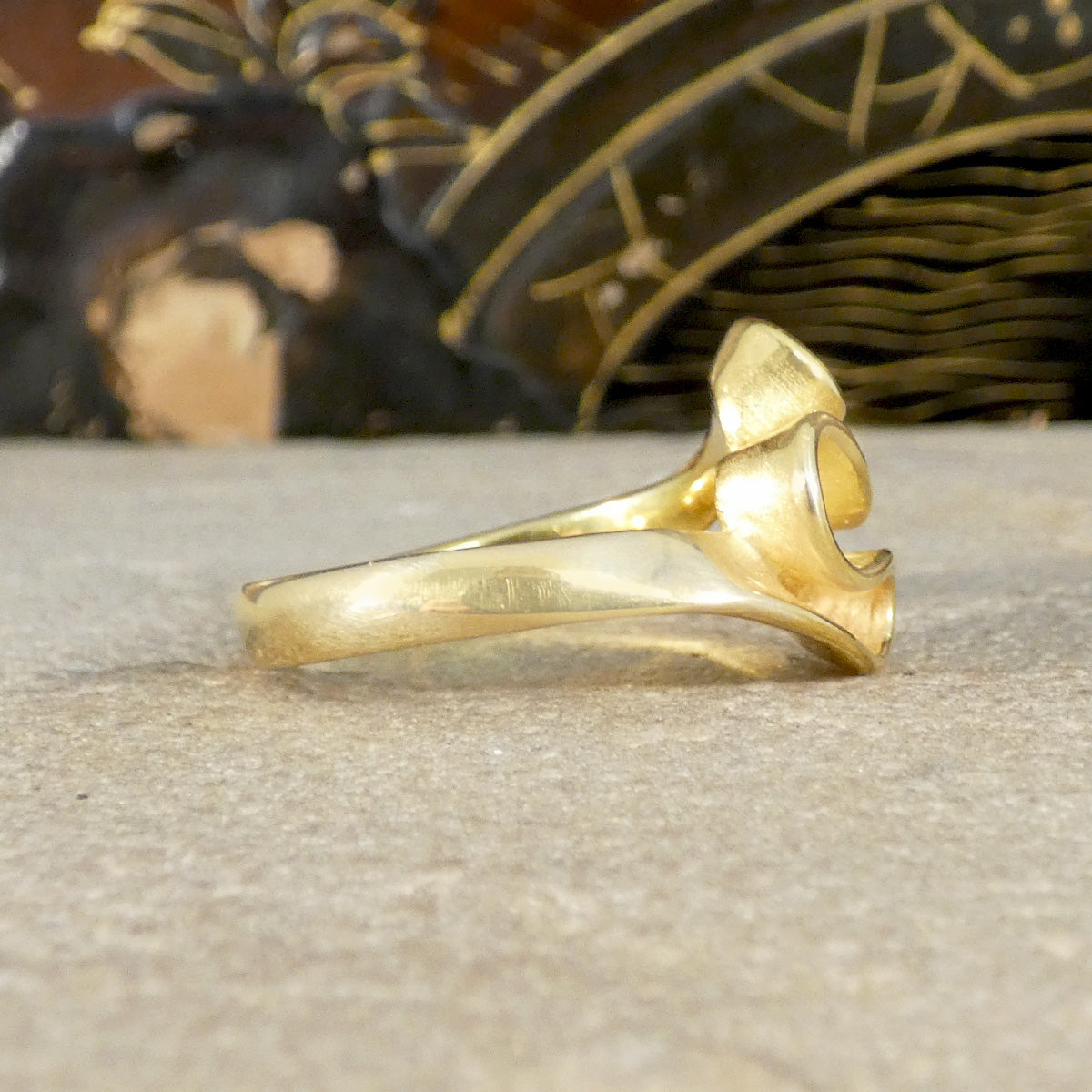 Gold ring on a textured surface with decorative elements in the background