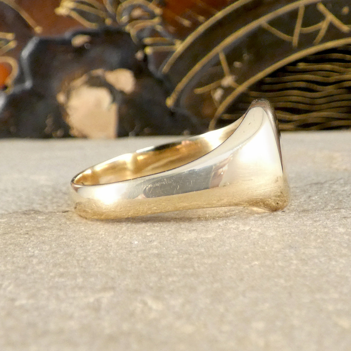 Gold ring on a textured surface with decorative elements in the background