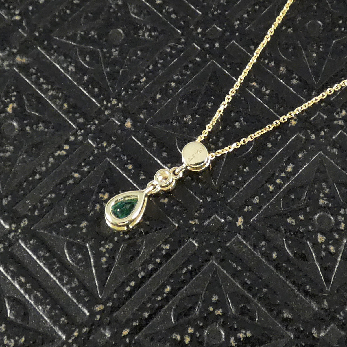 Reverse of Modern Emerald and Diamond Bezel Set Drop Pendant Necklace in Yellow Gold showing hallmarks on the back of the Emerald set bail.
