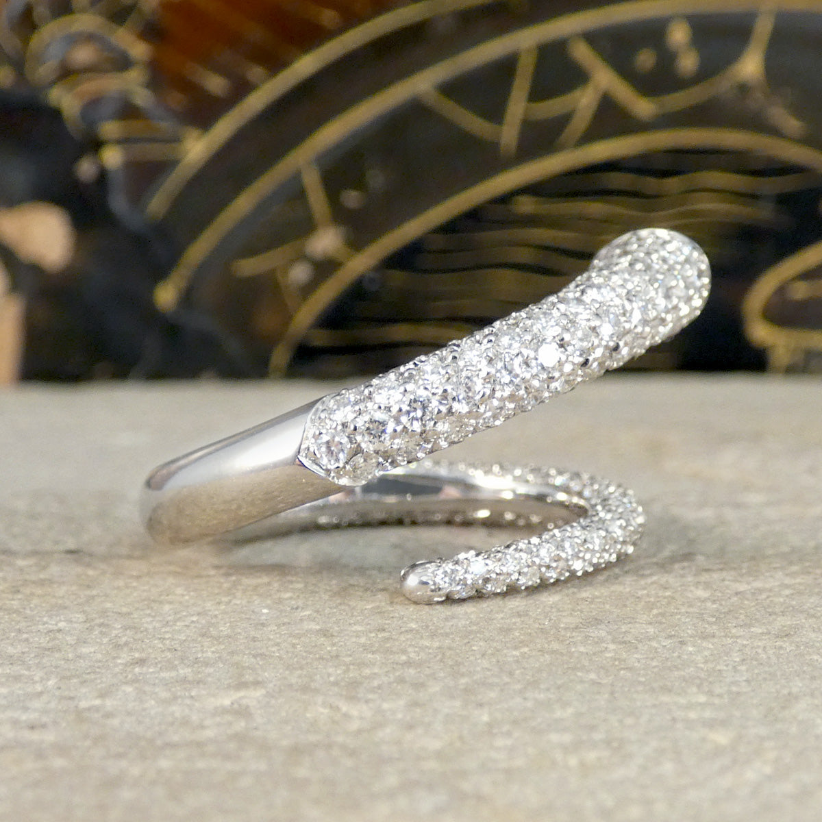 A unique diamond set snake like ring shown on a stone.