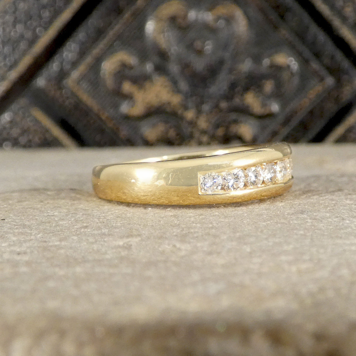 Gold ring with diamonds on a textured surface