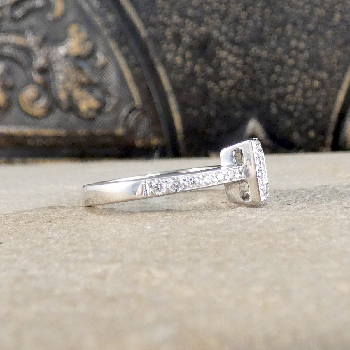 Silver ring with small diamonds on a textured surface