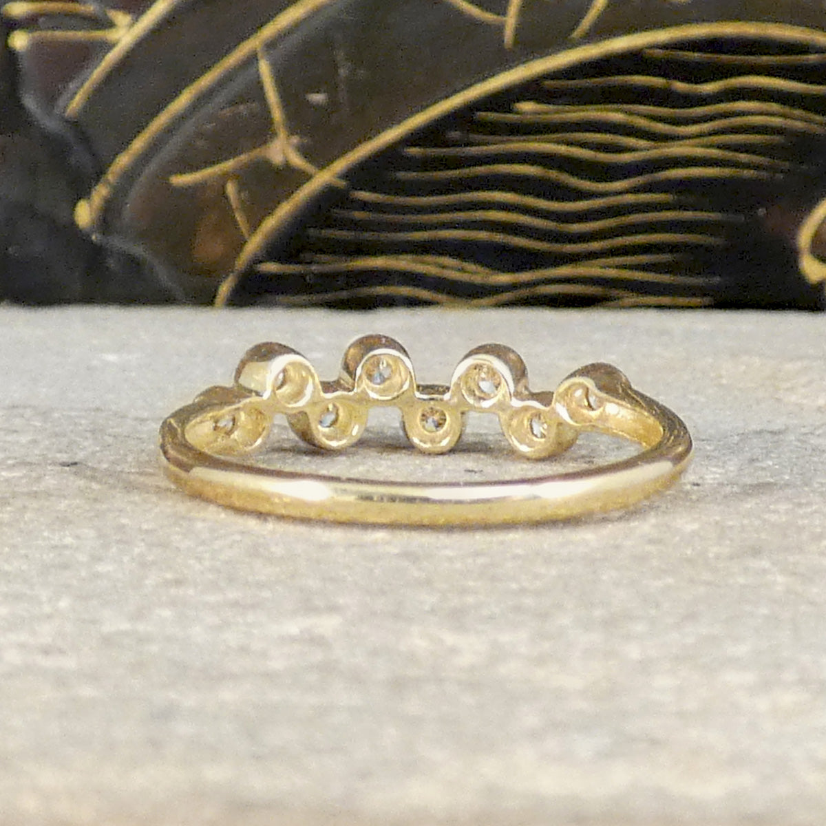 Back view of bubbled diamond band ring, showing the curves and settings from behind with a plain polished band.