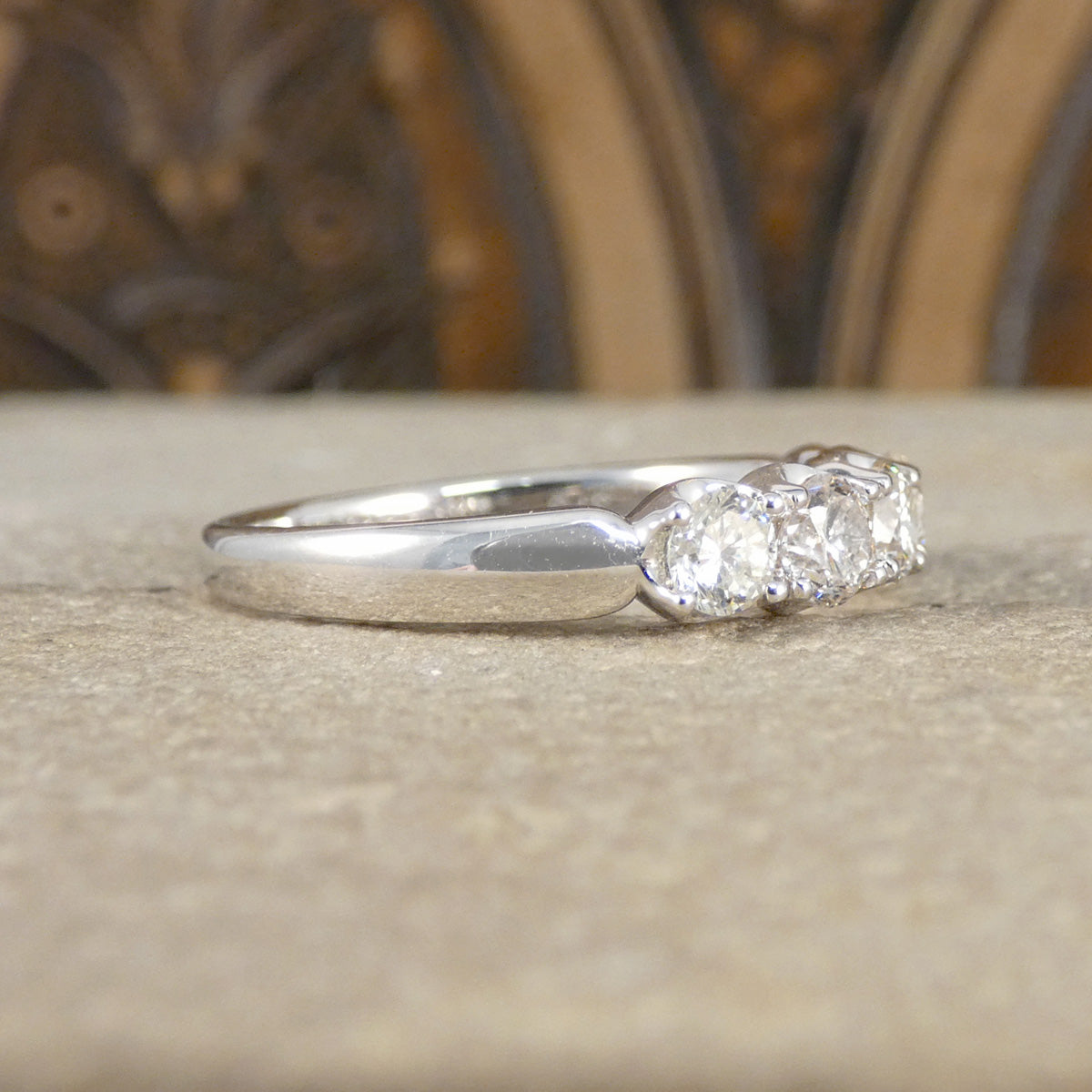 white gold ring with a diamond on a textured surface