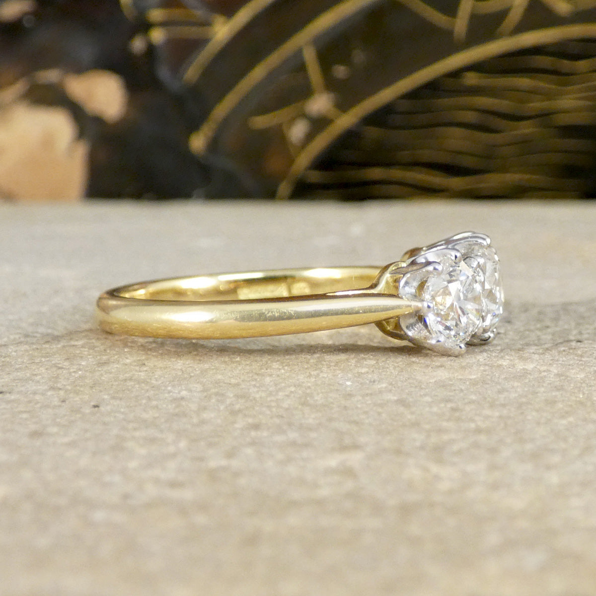 Gold ring with a diamond on a textured surface