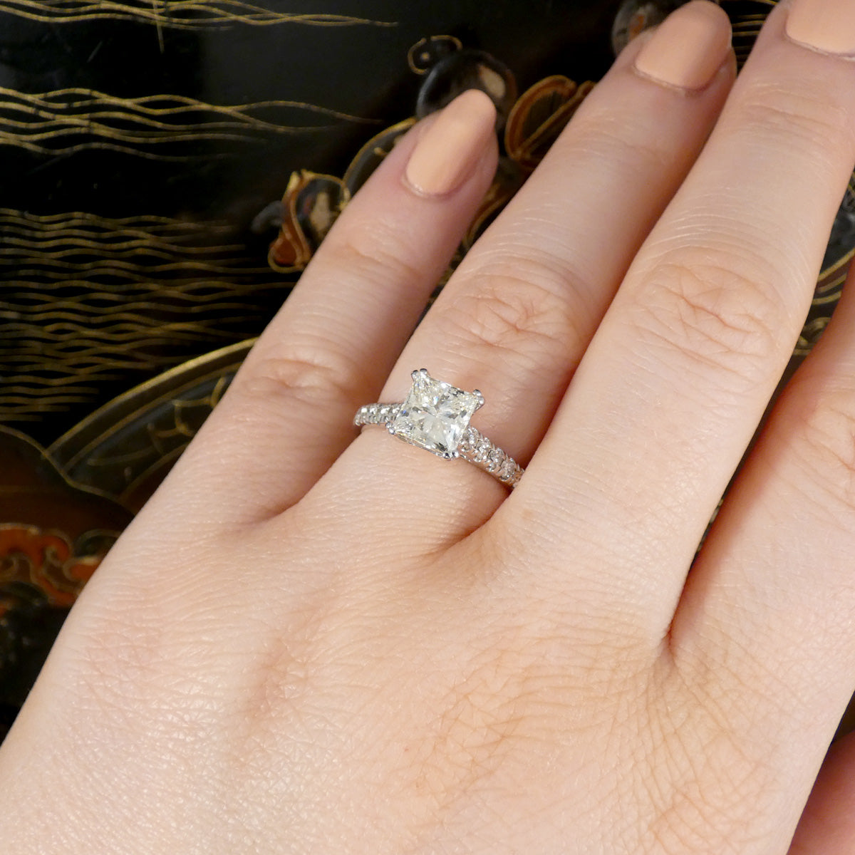 A gorgeous Princess cut Diamond Solitaire ring with diamond set shoulders in 18ct White Gold, the perfect engagement ring. Shown on the finger to show size ratio.